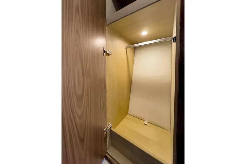 Slide: The Image of Interior closet of 2020 Riviera 4800 Sport Yacht with wooden finish and lighting. - 59