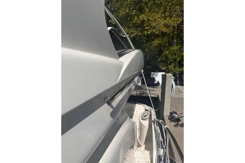 Slide: The Image of Side view of a 2007 Azimut 55E yacht docked, showcasing sleek design and mooring ropes. - 42