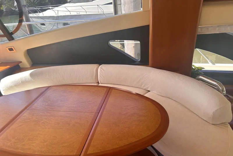 Slide: The Image of Luxurious interior of a 2007 Azimut 55E yacht with elegant wood table and curved seating. - 35