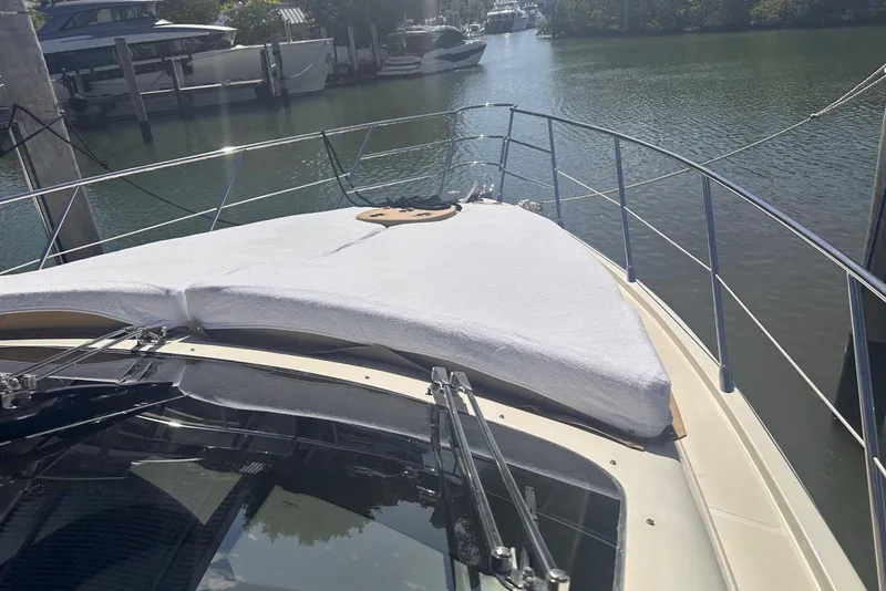 Slide: The Image of 2007 Azimut 55E yacht bow view with sunpad, docked in a serene marina. - 44
