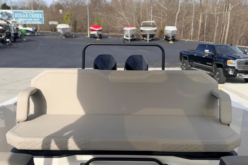 Slide: The Image of Rear view of 2026 Navan S30 boat with beige seating, parked near dealership. - 27