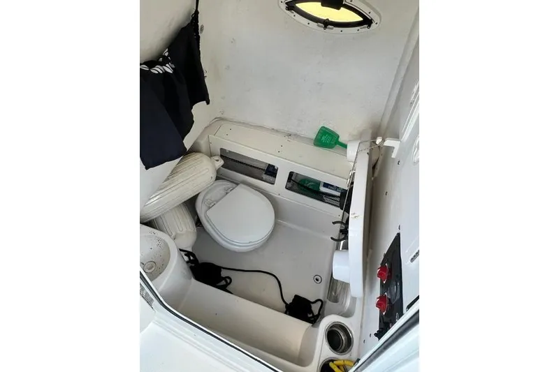 Slide: The Image of Interior of 2014 Sailfish 270 CC boat featuring compact marine toilet setup. - 10