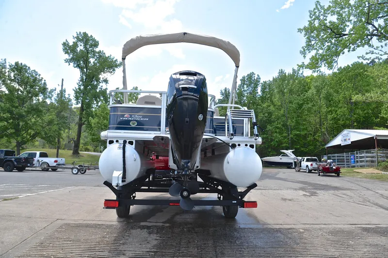 Slide: The Image of 2024 Sun Tracker Bass Buggy 18 DLX pontoon boat on trailer, parked outdoors. - 13