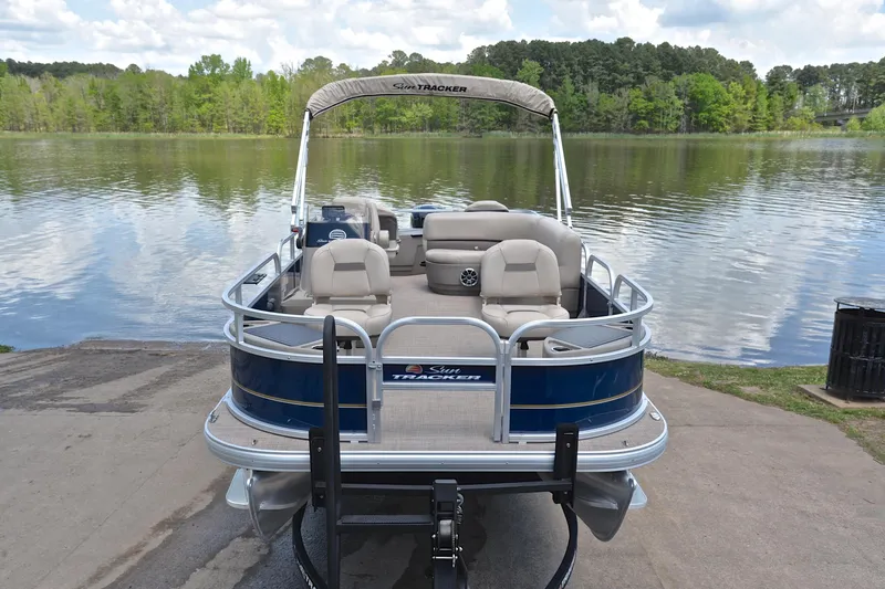 Slide: The Image of 2024 Sun Tracker Bass Buggy 18 DLX pontoon boat by a scenic lake. - 17