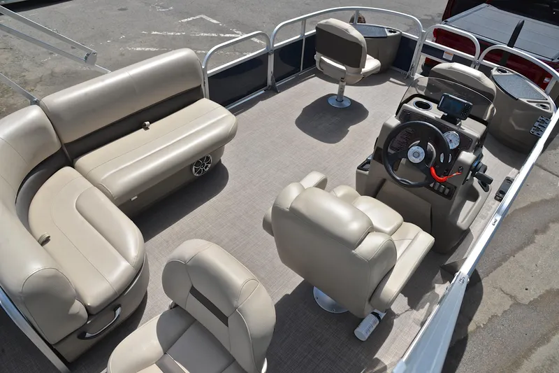 Slide: The Image of 2024 Sun Tracker Bass Buggy 18 DLX pontoon boat interior with beige seating and steering console. - 19