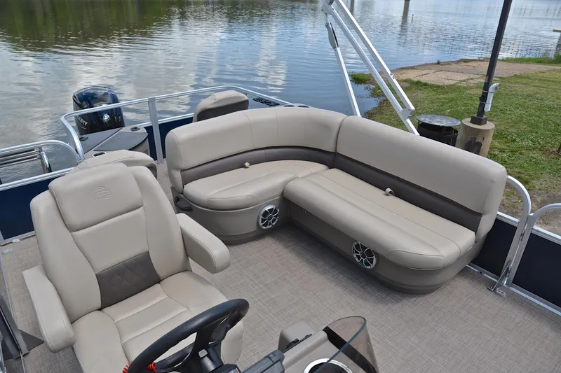 Slide: The Image of 2024 Sun Tracker Bass Buggy 18 DLX pontoon boat interior with plush seating and steering console. - 22