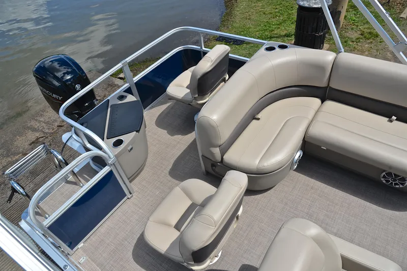 Slide: The Image of 2024 Sun Tracker Bass Buggy 18 DLX pontoon boat with beige seating and Mercury outboard motor. - 23