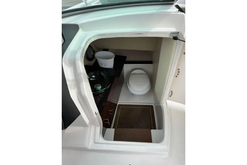 Slide: The Image of Interior view of a 2013 Regal 3200 Bowrider boat's compact bathroom area. - 13