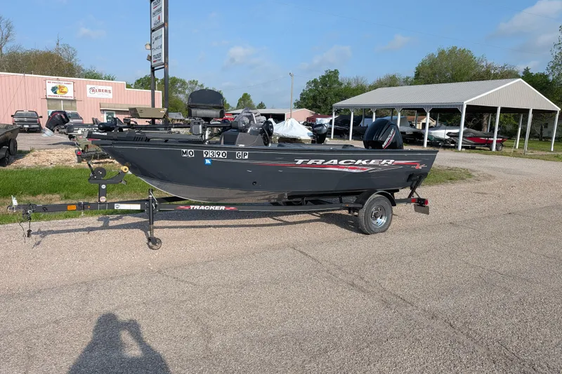 The Image of 2022 Tracker Pro Guide V-16 SC boat on trailer in outdoor dealership setting. - 72