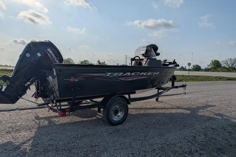 Slide: The Image of 2022 Tracker Pro Guide V-16 SC boat on trailer, parked on gravel under blue sky. - 78