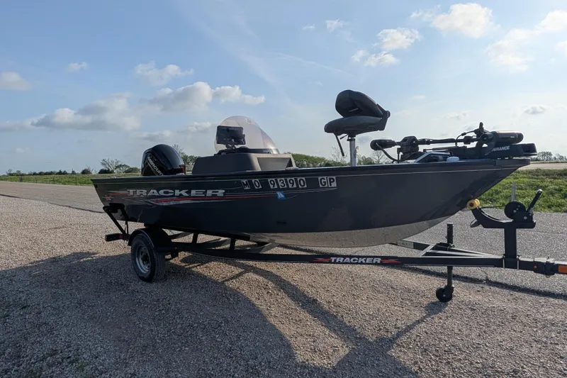 Slide: The Image of 2022 Tracker Pro Guide V-16 SC fishing boat on trailer, parked on gravel road. - 80