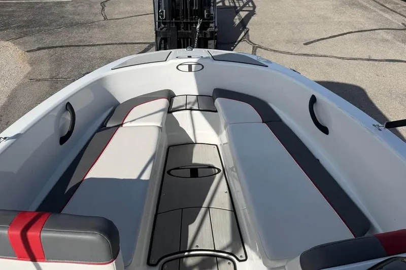 Slide: The Image of 2020 Tahoe T16 boat interior with gray and red seating, docked on pavement. - 12