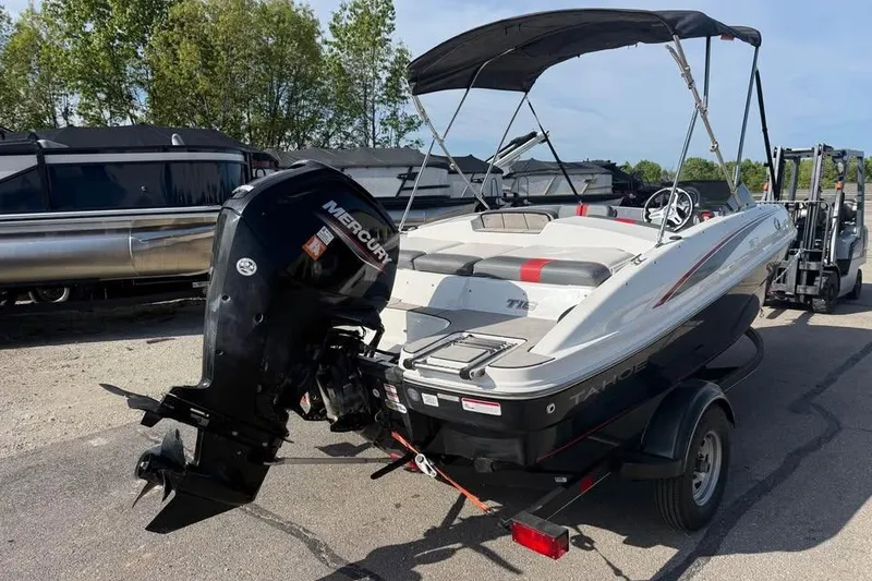 Slide: The Image of 2020 Tahoe T16 boat with Mercury outboard motor on trailer, parked outdoors. - 7