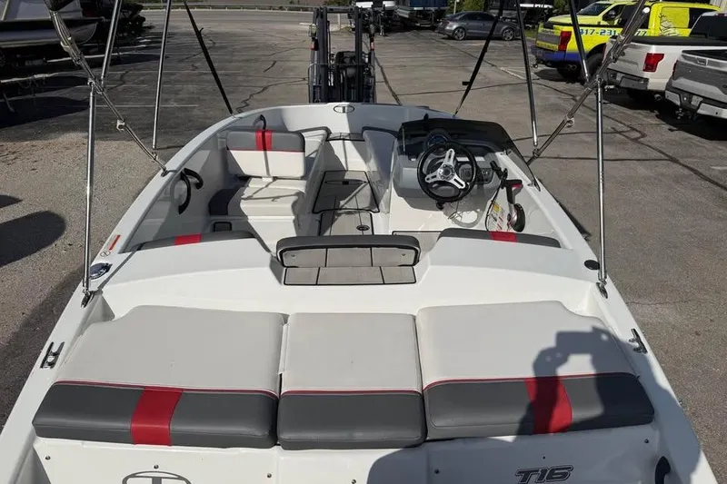 Slide: The Image of 2020 Tahoe T16 boat interior with seating and steering wheel in a parking lot. - 8