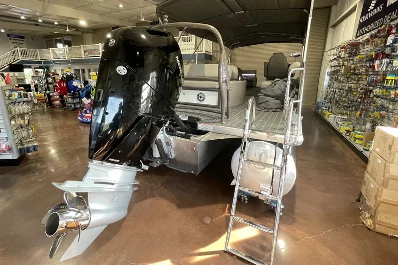 Slide: The Image of 2024 Premier 270 Intrigue pontoon boat with powerful outboard motor in showroom. - 4