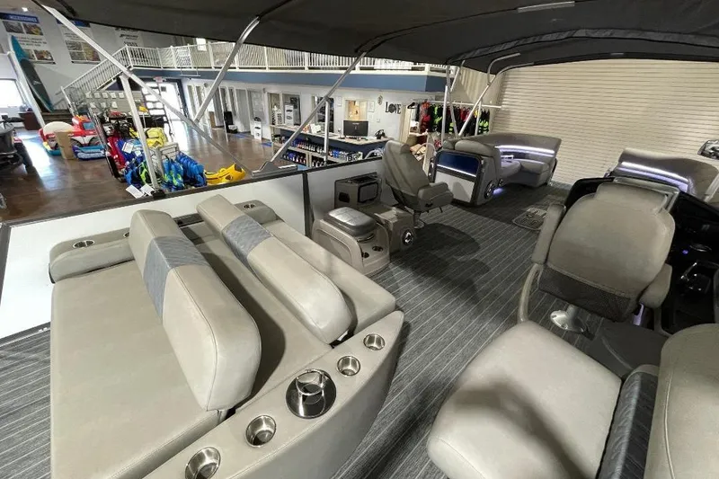 Slide: The Image of 2024 Premier 270 Intrigue boat interior with luxurious seating and modern design in showroom. - 8