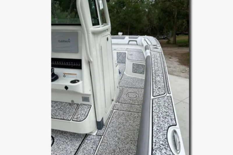 Slide: The Image of 2018 World Cat 320 CC boat deck with Garmin equipment, featuring textured flooring. - 10