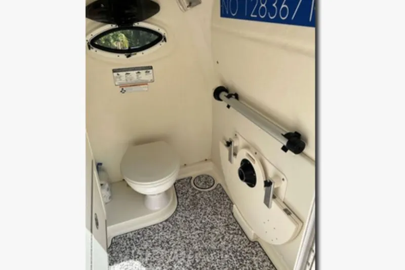 Slide: The Image of Interior of 2018 World Cat 320 CC boat bathroom with toilet and porthole. - 11