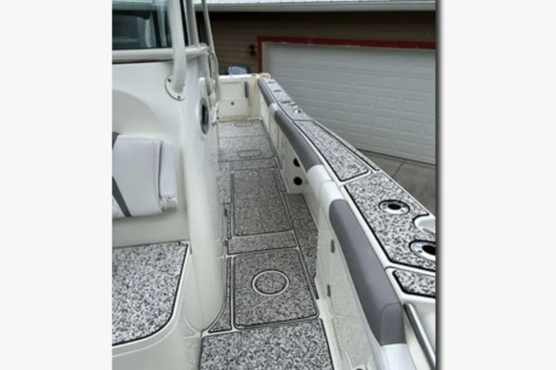 Slide: The Image of 2018 World Cat 320 CC boat deck with textured flooring and rod holders. - 15