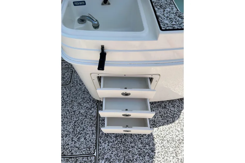 Slide: The Image of 2018 World Cat 320 CC boat with open storage drawers and sink. - 19