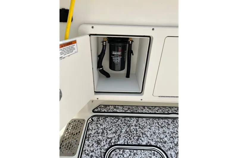 Slide: The Image of Open compartment on 2018 World Cat 320 CC boat showing a filter system. - 27