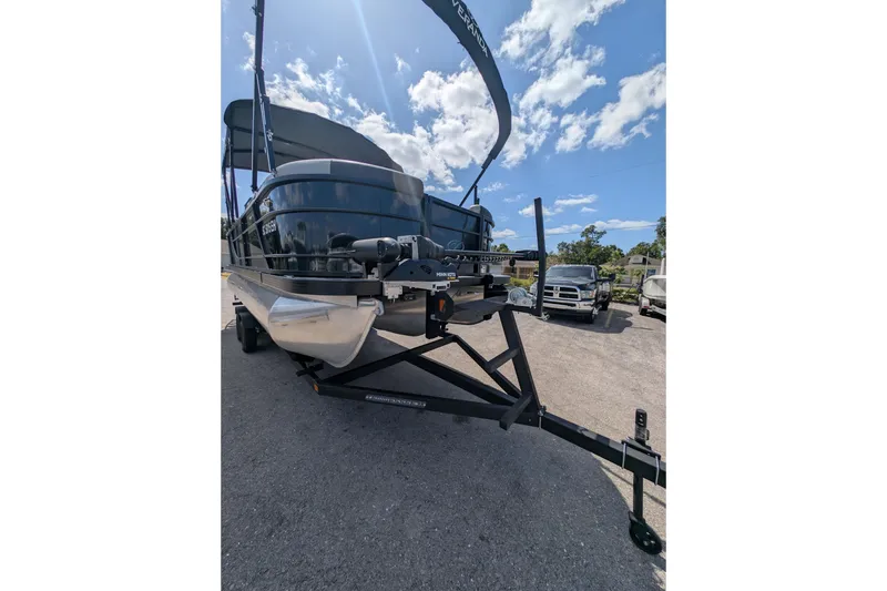 Slide: The Image of 2025 Veranda Relax VR 22 RC pontoon boat on trailer under sunny sky. - 12