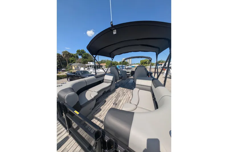Slide: The Image of 2025 Veranda Relax VR 22 RC pontoon boat with spacious seating and canopy under clear blue sky. - 2