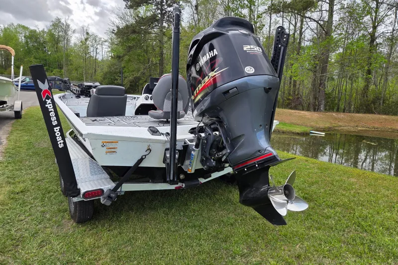 Slide: The Image of 2021 Xpress X21 Pro boat with Yamaha 250 engine, parked on grass near water. - 3