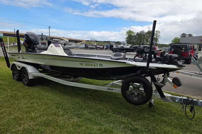 Slide: The Image of 2021 Xpress X21 Pro boat on trailer, parked on grass under a cloudy sky. - 6