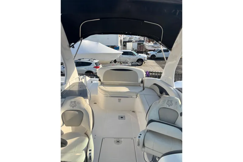 Slide: The Image of 2012 Chaparral 267 SSX boat interior with seating and canopy, parked near vehicles. - 5