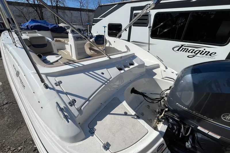 Slide: The Image of 2013 Hurricane SunDeck Sport 203 OB boat with Yamaha outboard motor, parked beside RV. - 3