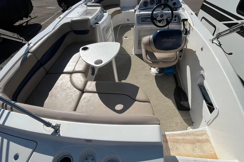Slide: The Image of 2013 Hurricane SunDeck Sport 203 OB interior with seating, steering wheel, and table. - 4