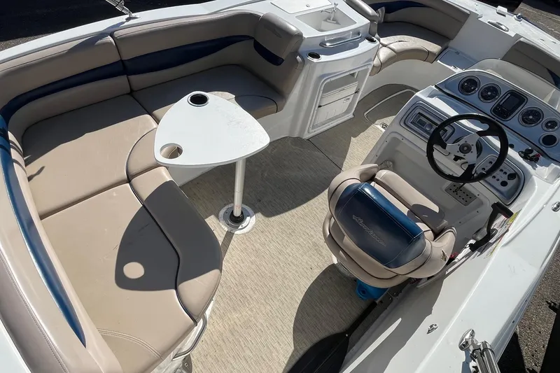 Slide: The Image of 2013 Hurricane SunDeck Sport 203 OB boat interior with seating, steering wheel, and table. - 5
