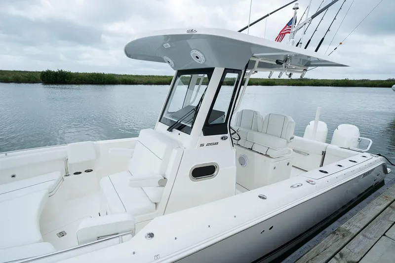 Slide: The Image of Manufacturer Provided Image: 2022 Pursuit S 268 Sport boat docked by a serene lake. - 10