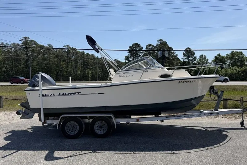 The Image of 2003 Sea Hunt Victory 215 boat on trailer, parked outdoors under clear sky. - 0
