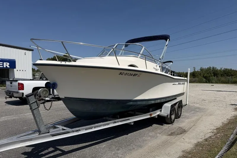 Slide: The Image of 2003 Sea Hunt Victory 215 boat on trailer, parked outdoors under clear sky. - 10