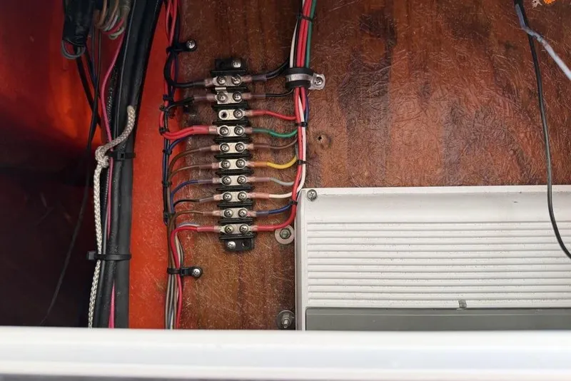 Slide: The Image of Electrical wiring panel inside a 2003 Sea Hunt Victory 215 boat, showcasing organized cables. - 13