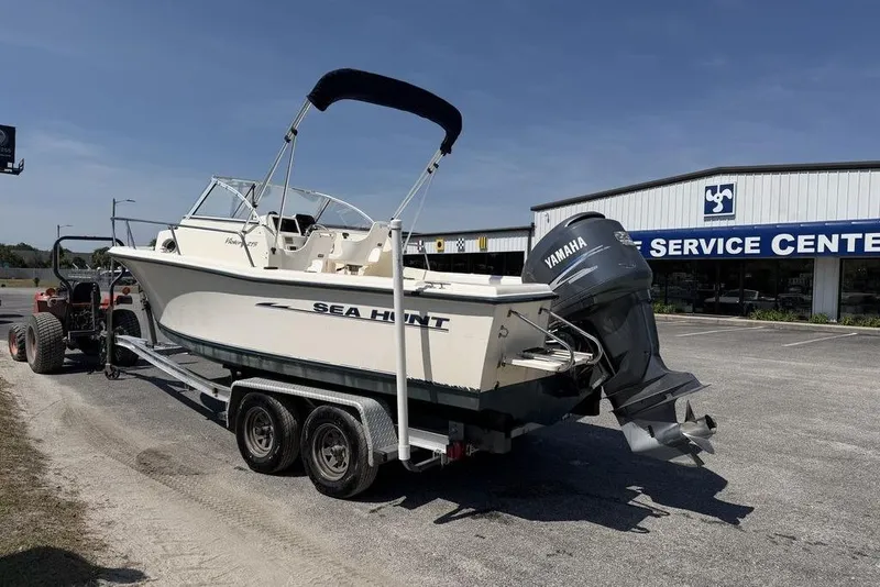 Slide: The Image of 2003 Sea Hunt Victory 215 boat on trailer near service center, featuring Yamaha outboard motor. - 6