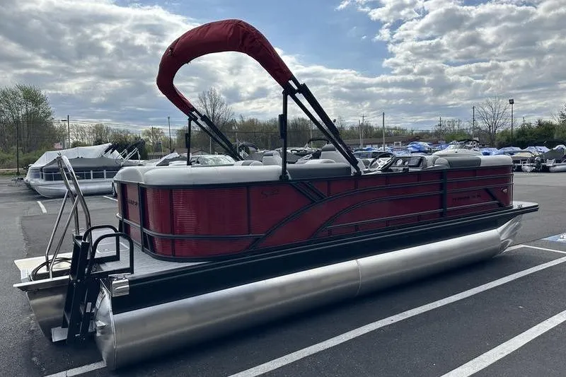 Slide: The Image of 2026 Bennington S Swingback 22 SSB pontoon boat with red canopy in parking lot. - 10