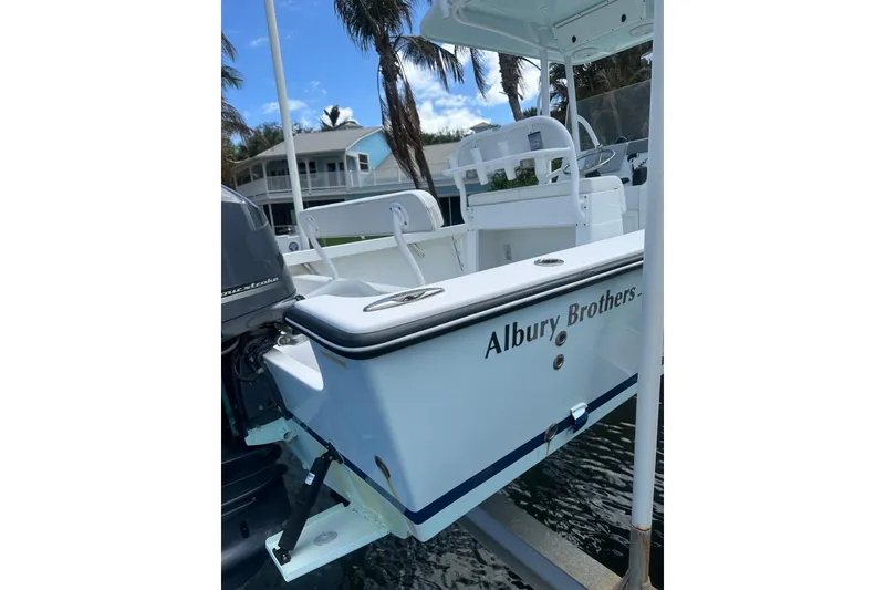 Slide: The Image of 2018 Albury Brothers 23 boat docked, featuring sleek design and outboard motor. - 6