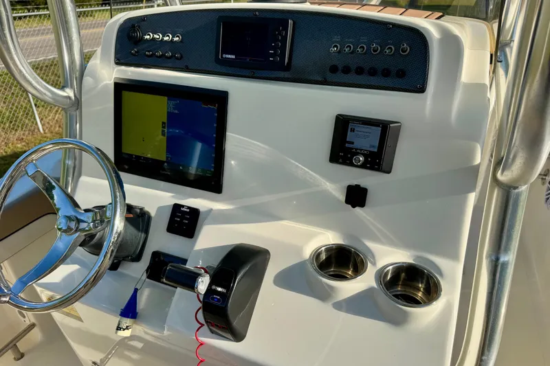 Slide: The Image of 2019 Pioneer 222 Sportfish boat dashboard with steering wheel, controls, and electronic displays. - 15