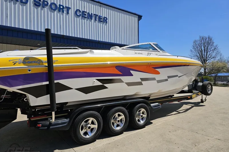 Slide: The Image of 2001 Powerquest 340 Vyper boat with vibrant graphics on a trailer outside a sport center. - 10