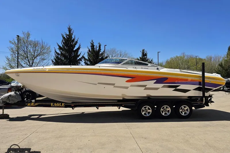 Slide: The Image of 2001 Powerquest 340 Vyper boat on trailer, vibrant graphics, parked outdoors. - 17