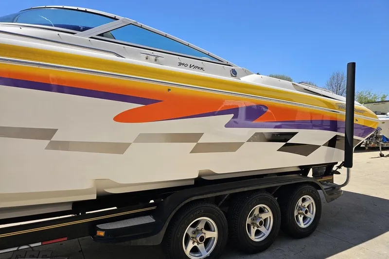 Slide: The Image of 2001 Powerquest 340 Vyper boat with vibrant graphics on a trailer. - 18