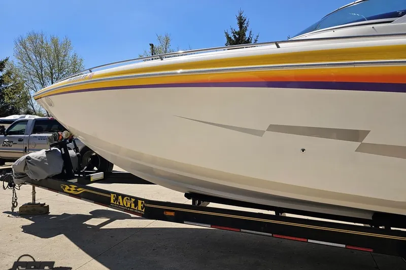 Slide: The Image of 2001 Powerquest 340 Vyper boat on trailer, vibrant stripes, sunny day. - 19