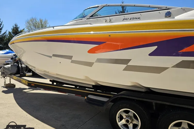 Slide: The Image of 2001 Powerquest 340 Vyper boat with vibrant graphics on a trailer. - 20