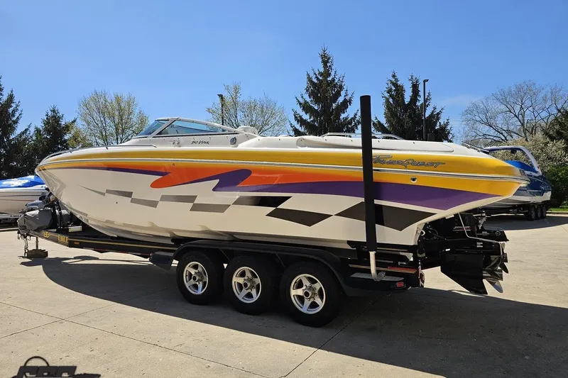Slide: The Image of 2001 Powerquest 340 Vyper boat on trailer, vibrant graphics, parked outdoors. - 22