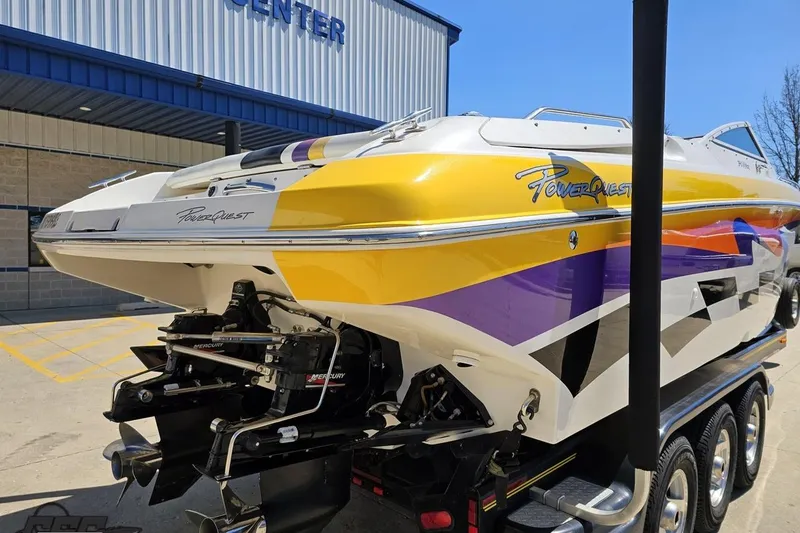 Slide: The Image of 2001 Powerquest 340 Vyper boat with vibrant yellow and purple design on a trailer. - 25