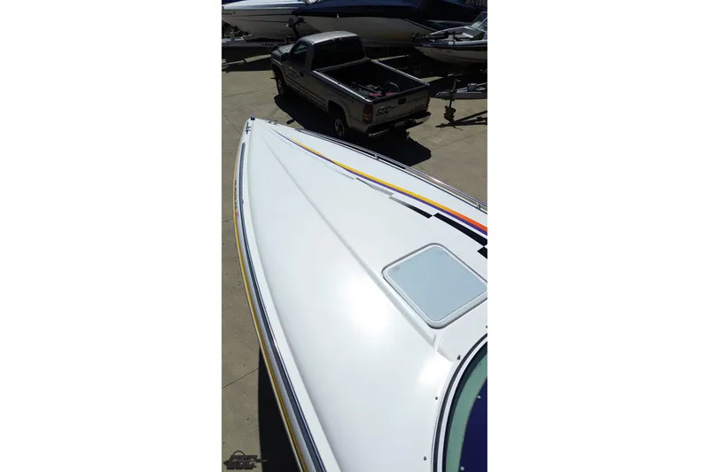 Slide: The Image of 2001 Powerquest 340 Vyper boat with sleek white deck and colorful stripes. - 39