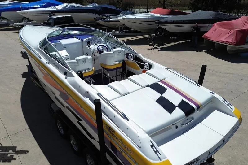 Slide: The Image of 2001 Powerquest 340 Vyper speedboat with vibrant graphics, parked on a trailer. - 43